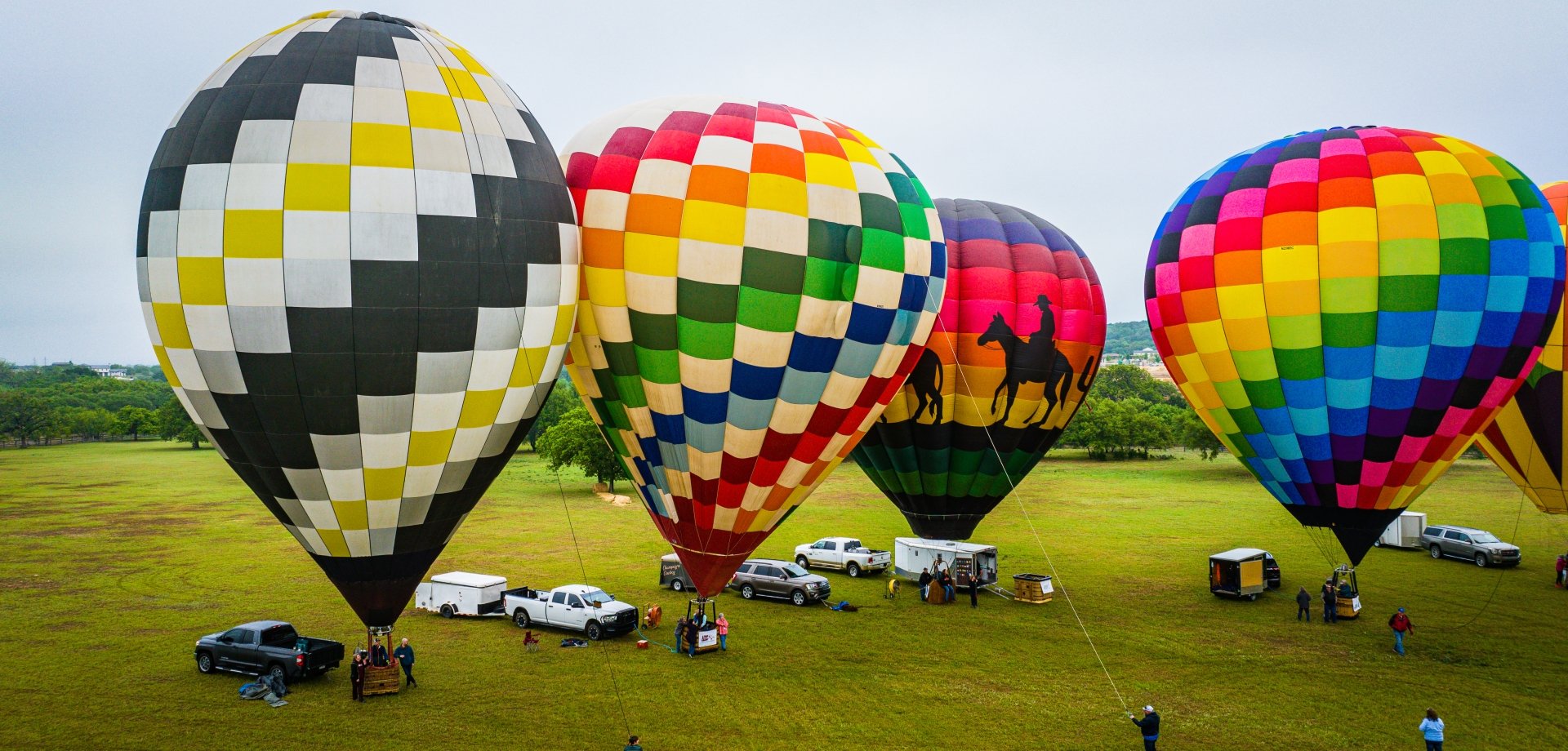 4 hot air balloons next to each other getting ready to float, at horseshoe bay resort texas